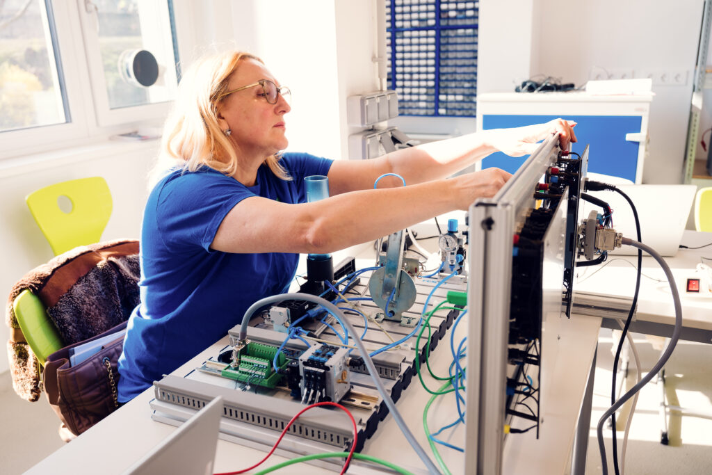 Frau arbeitet an Kabeln in LAP Vorbereitung Elektrotechnik