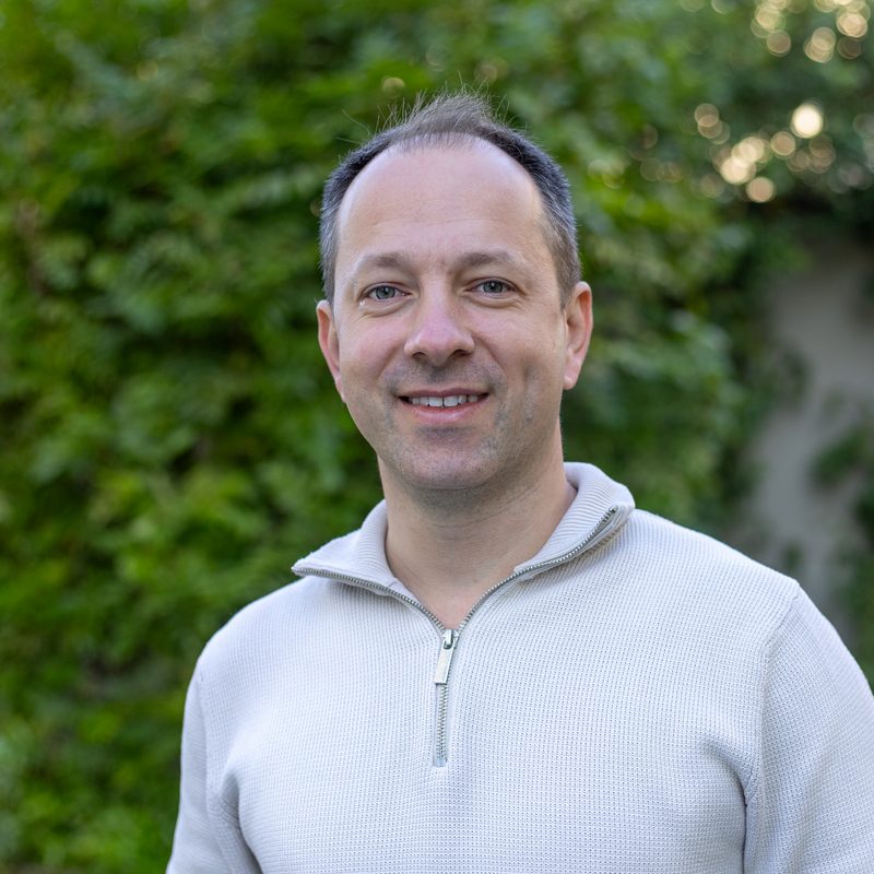 Porträt von Mario Jakic, Leiter der BPI Akademie, vor einer begrünten Wand